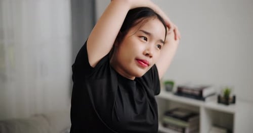 Young Woman Stretching Arms Before Workout at Home