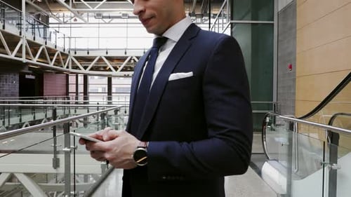 Businessman Using Smart Phone on Office Atrium Balcony 2529 Years