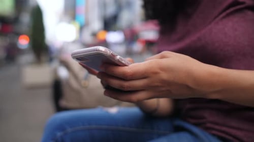 A young Latina woman types out a message on her phone SLOW MOTION