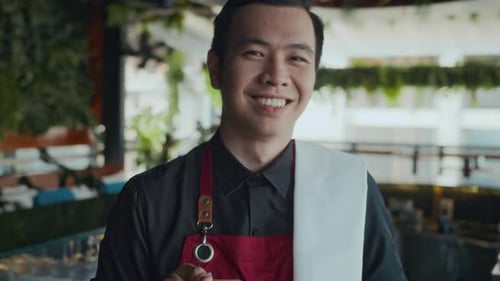 Portrait of Young Barman Smiling behind Bar