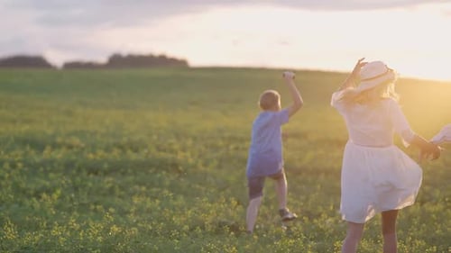 Handheld Family Outdoor Recreation a Boy with His Parents Running Through the Field and Launching a