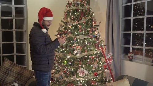 Man Decorating Christmas Tree at Home