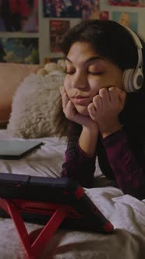 Girl Looks at Tablet Display While Watches Movie or Video Content