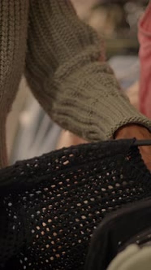 A Person is Engaged in Sorting Through Clothing Items in a Trendy Boutique Environment