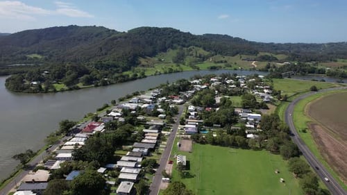 Riverfront Houses With View Of Vegetated Hill Across Tweed River In Tumbulgum, NSW, Australia. aeria