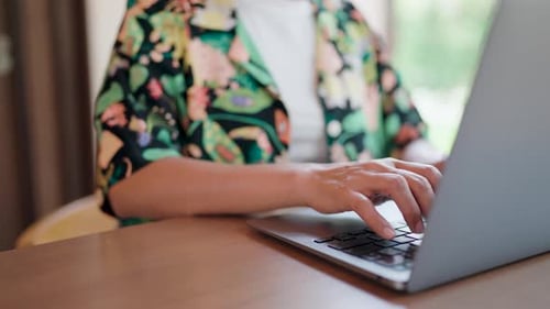 Close-up of hands working on laptop using hands typing on keyboard.