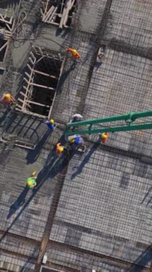 Vertical Video of Residential Construction With Active Crane Work and Skilled Workers Building Walls