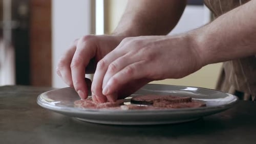 Chef meticulously plating sliced meat in bright kitchen