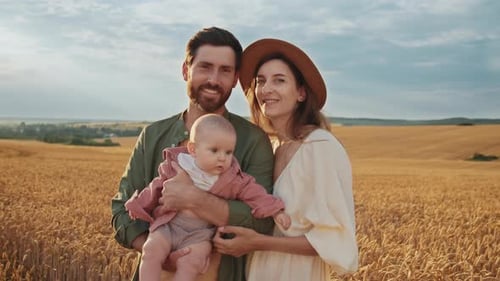 Loving Family with Infant in Golden Wheat Field