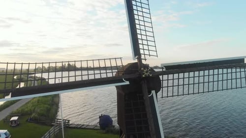 Vue aérienne d'un petit moulin à vent près du lac au lever du soleil, Oudega, Pays-Bas
