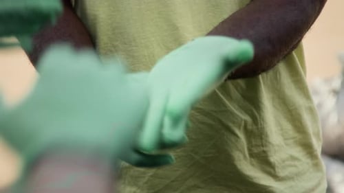 Team Stacking Hands Wearing Protective Green Gloves