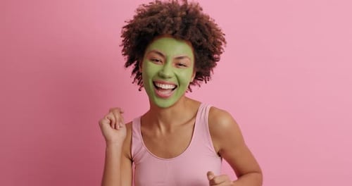 Excited Woman with Green Facial Mask Having Fun
