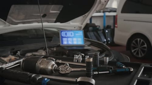 Laptop with Engine Diagnostics Program and Wrench on Tool Cart in Auto Garage