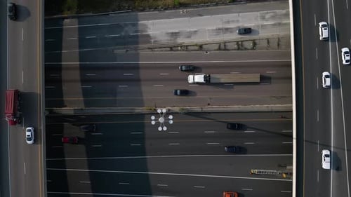 Cars driving on modern highway infrastructure with multiple roadways and interchanges