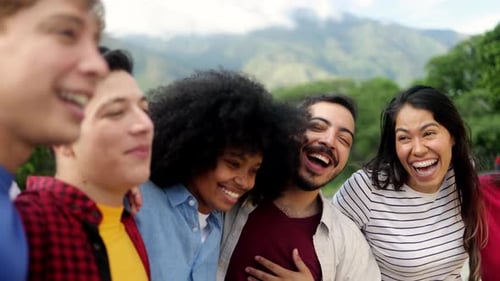 Friends hugging and smiling in summer park during vacation