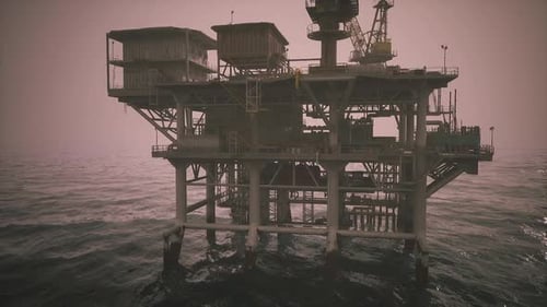 Oil Rig Stands Tall in Foggy Waters During Early Morning Hours