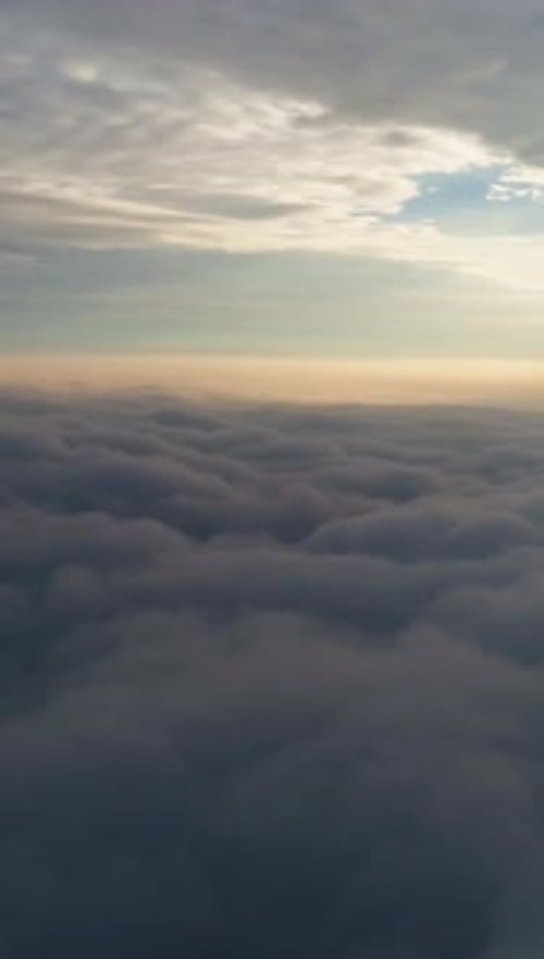 Flying to the Right Above Beautiful Dramatic Clouds at Sunrise Aerial View Vertical Video