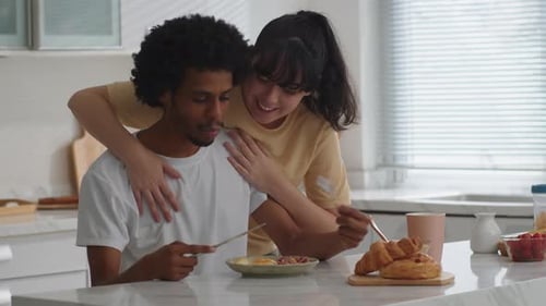 Affectionate Couple Shares Breakfast in Bright Kitchen