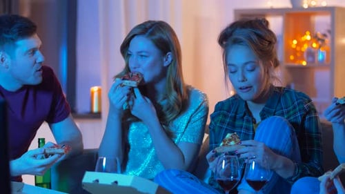 Friends Eat Pizza and Chat on Sofa at Home