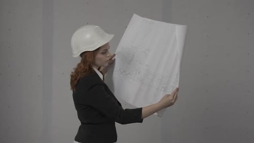 Side View of an Architect Woman Holding a Plan in Her Hands A Woman is Studying the Project Plan