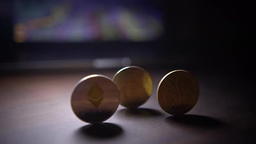 Cryptocurrency Coins Standing in the Dark with Monitor