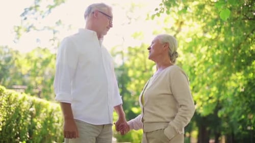 Senior Couple Holding Hands in Green Park Setting
