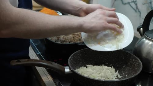 Home Cook Pouring Chopped Onions Into Pan