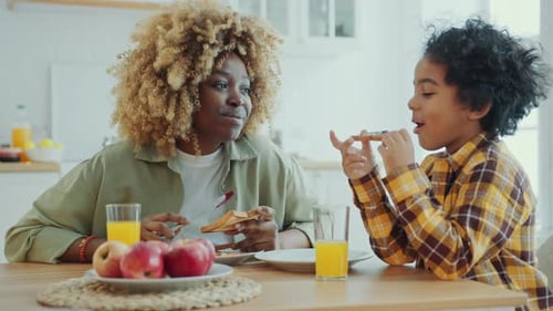 Woman and Child Enjoying Breakfast Together in Kitchen