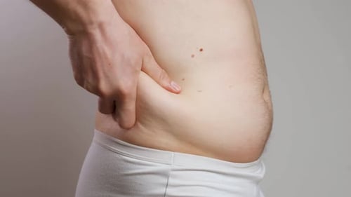 Man Pinches Abdomen Flesh, Evaluates Weight