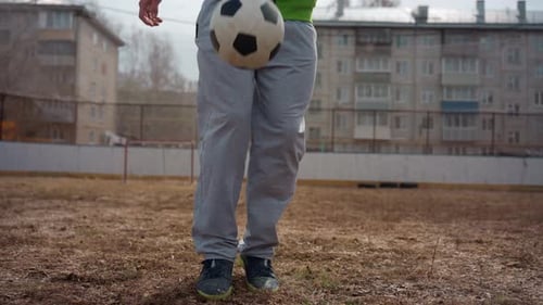 Person juggling soccer ball with feet on field