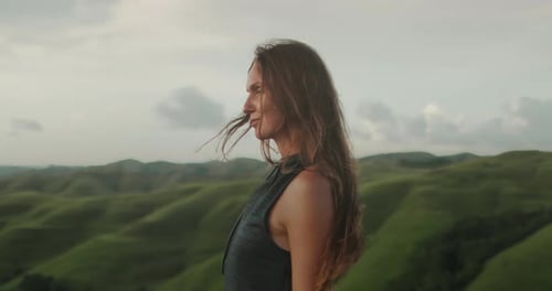 Woman Enjoy Green Hills Landscape at Sunset
