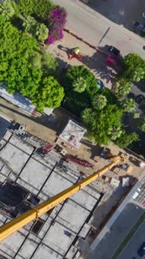 Vídeo vertical: Ingenieros expertos construyen cuidadosamente una grúa torre pieza por pieza en un entorno vibrante
