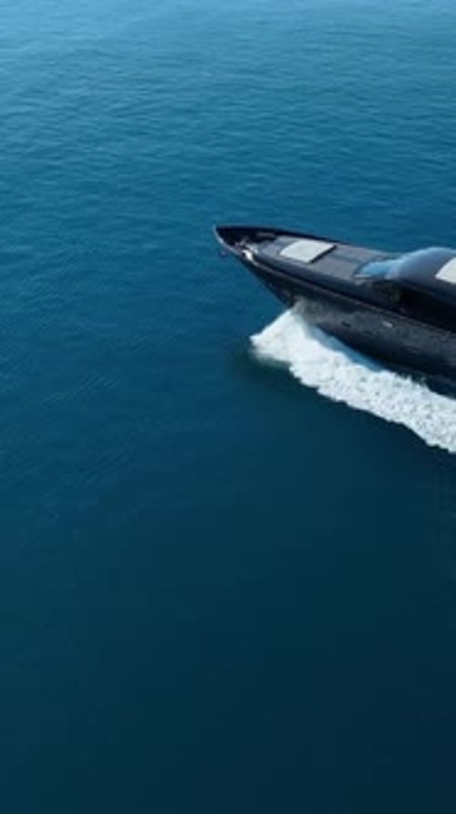 Luxury Yacht on the Ocean: A sleek, modern yacht cuts through the tranquil, deep blue ocean waters,