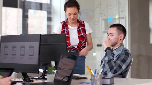 Two Colleagues Discussing UI Design in a Modern Office