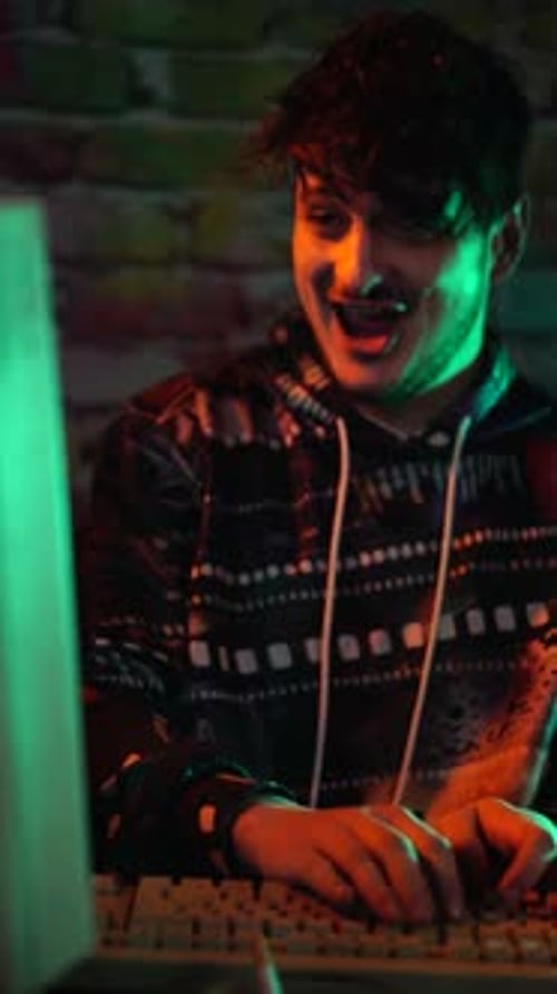 Vertical View of Young Excited Man in Front of Vintage PC Computer Celebrating Success