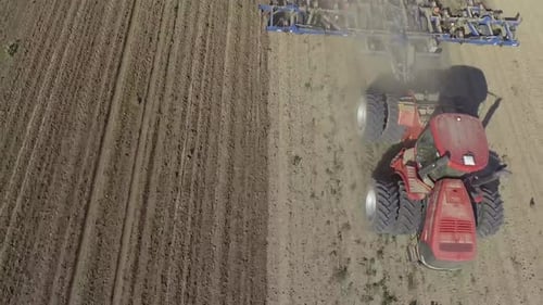 Big red tractor working on the field cultivating and applying nitrogen ASP