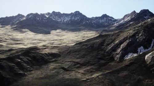 Una vista de una cadena montañosa desde la cima de una colina