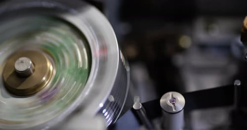Tight close-up shot of an interior of a vintage VHS tape recorder - record head starts spinning with