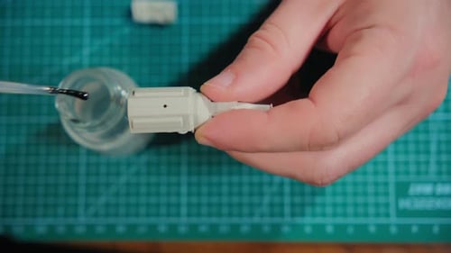 Homme assembleur modèle en plastique de voiture dans une pièce à table selon les dessins et les instructions en gros plan