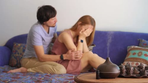 Une jeune femme est stressée, son partenaire essaie de la réconforter