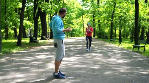 Couple of Joggers Eat Apple, Resting After Jogging in Park Active