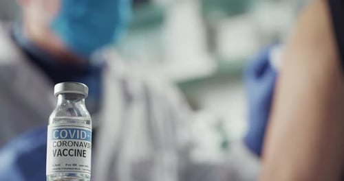 Cinematic shot of male doctor or nurse is making injection of coronavirus vaccine to patient for a