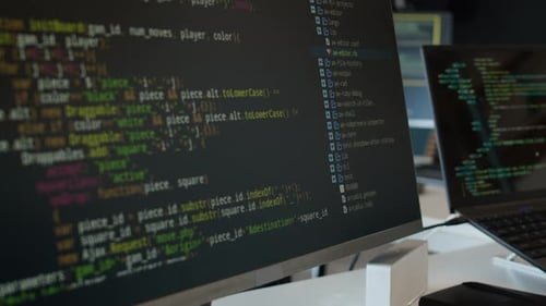 Computer Code Displayed on a Monitor with Laptop