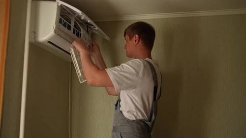 Man Maintains Air Conditioner in Home