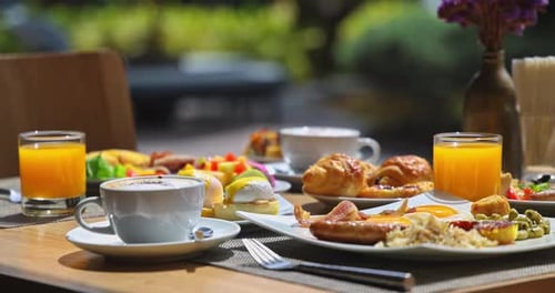 Luxury breakfast spread on outdoor terrace table under morning sun