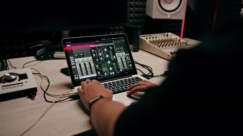 ingeniero de sonido de estudio de grabación profesional con dedo ajusta el nivel de volumen en la consola de mezclas