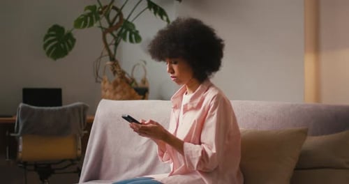 Woman Using Smartphone on Couch Indoors