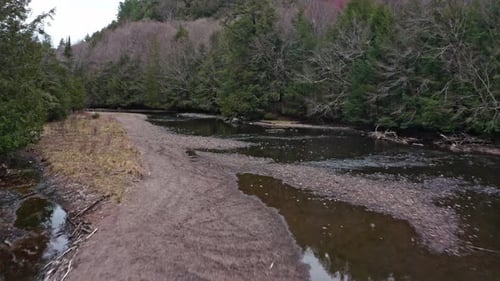 Fast drone shot following a shallow river in Canada