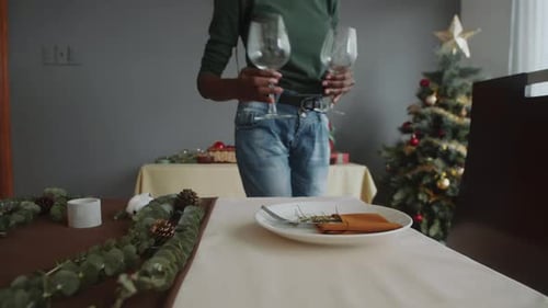 Woman Prepares Christmas Dinner Table in Home