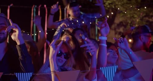 Enthusiastic group of friends partying at night